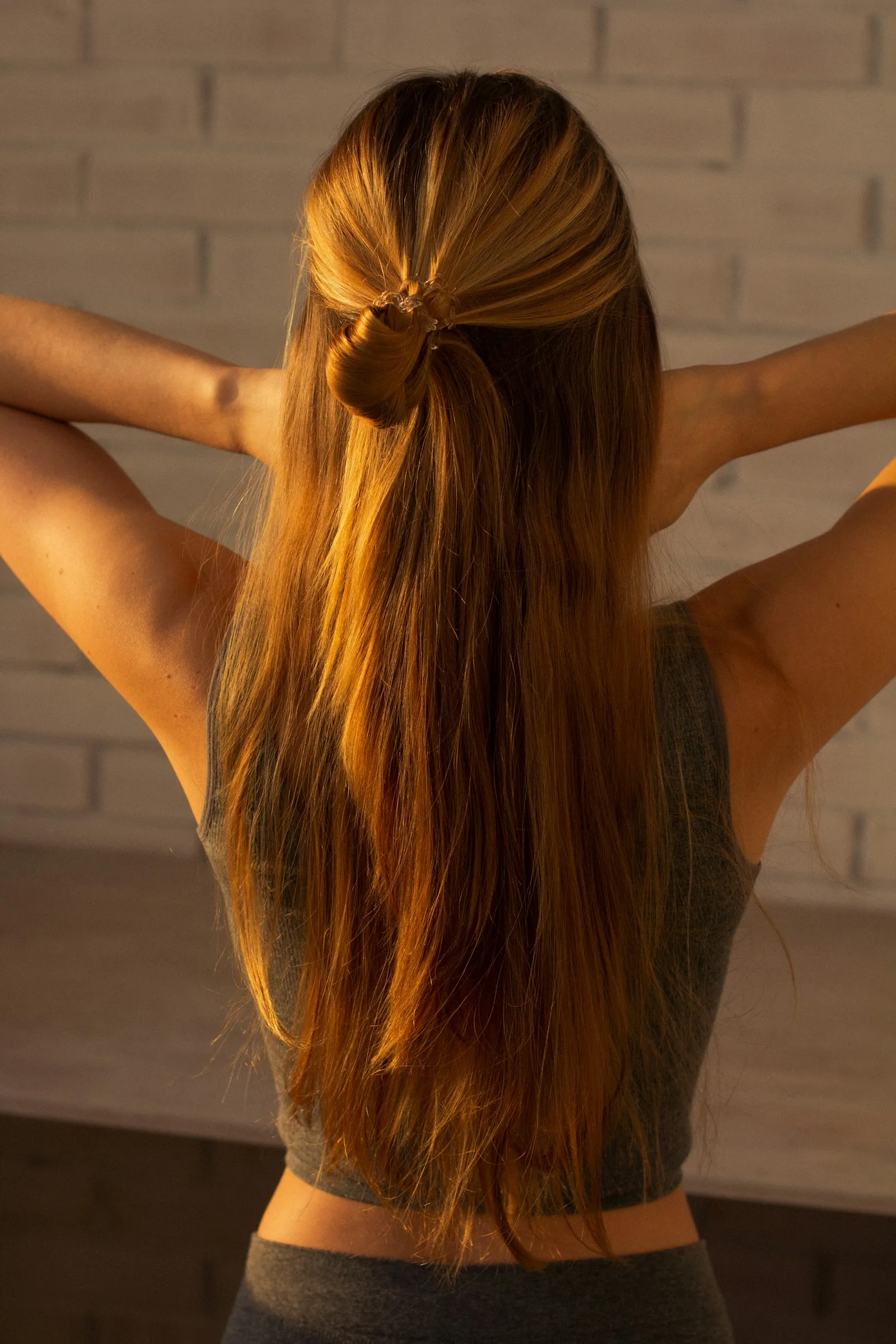 Symbolbild: lange, warm leuchtende Haare in der Rückansicht